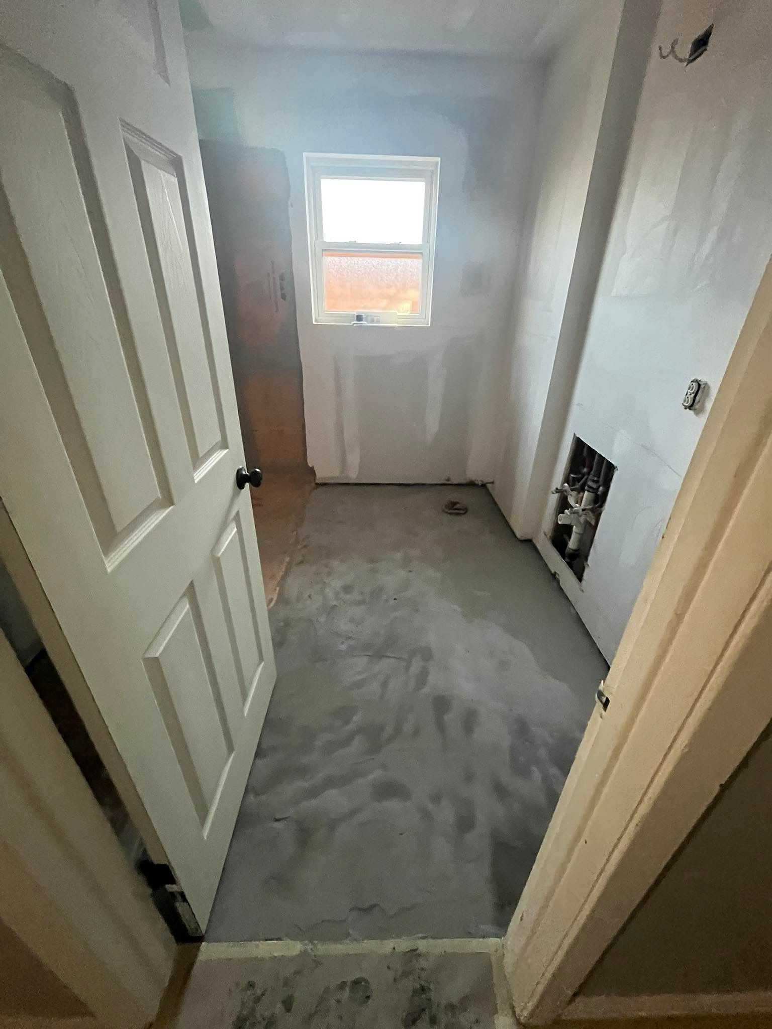 A hall bath taken down to bare slab and drywall